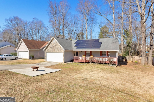 view of front of property featuring a garage, a wooden deck, a front yard, and solar panels