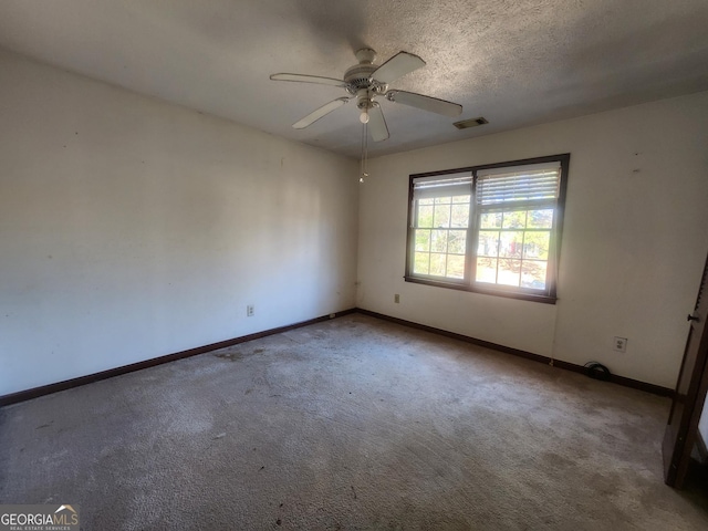 spare room featuring ceiling fan, carpet floors, and a textured ceiling