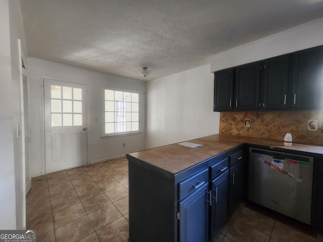 kitchen featuring blue cabinets, a textured ceiling, light tile patterned floors, dishwasher, and decorative backsplash