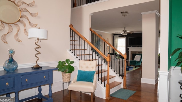 1320 Newbridge Cir, Buford, GA 30519 - stairway featuring ceiling fan, a fireplace, wood finished floors, and ornamental molding