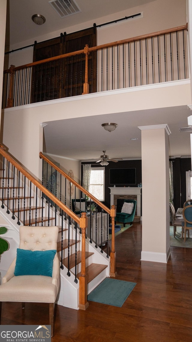1320 Newbridge Cir, Buford, GA 30519 - stairway featuring a high ceiling, wood finished floors, a fireplace, and a ceiling fan