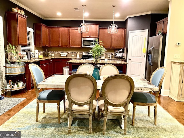 1320 Newbridge Cir, Buford, GA 30519 - kitchen featuring appliances with stainless steel finishes, ornamental molding, wood finished floors, pendant lighting, and light stone counters