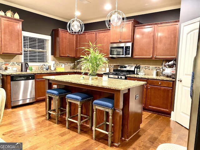 1320 Newbridge Cir, Buford, GA 30519 - kitchen with stainless steel appliances, a center island, backsplash, a breakfast bar, and ornamental molding