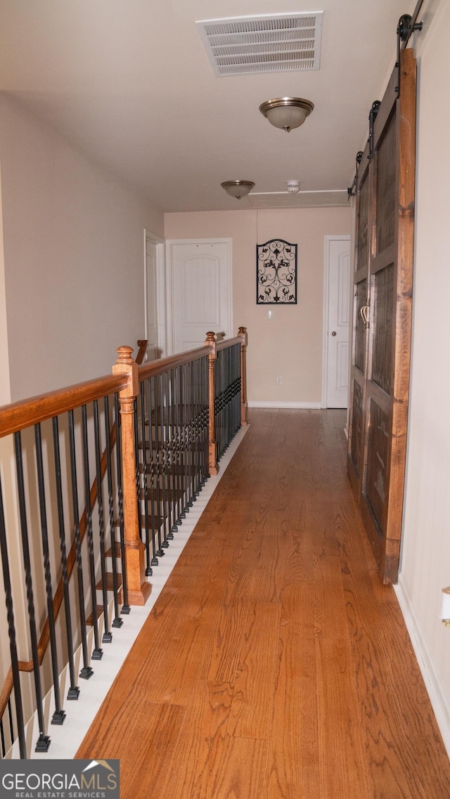 1320 Newbridge Cir, Buford, GA 30519 - corridor with an upstairs landing, a barn door, and wood finished floors