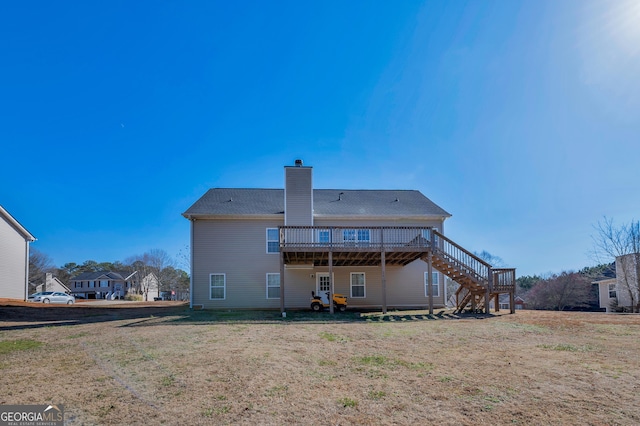 rear view of house with a yard and a deck