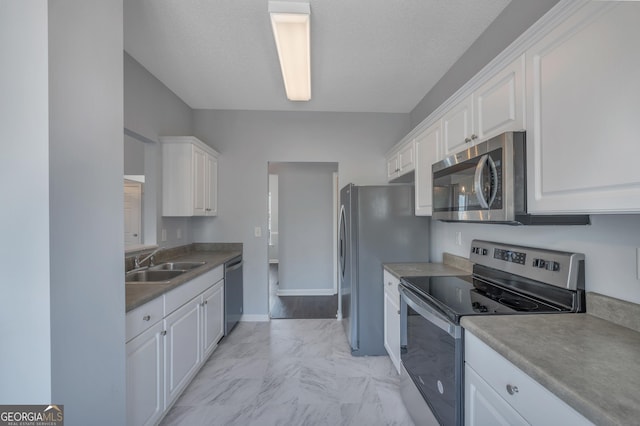 kitchen featuring white cabinetry, appliances with stainless steel finishes, sink, and a textured ceiling