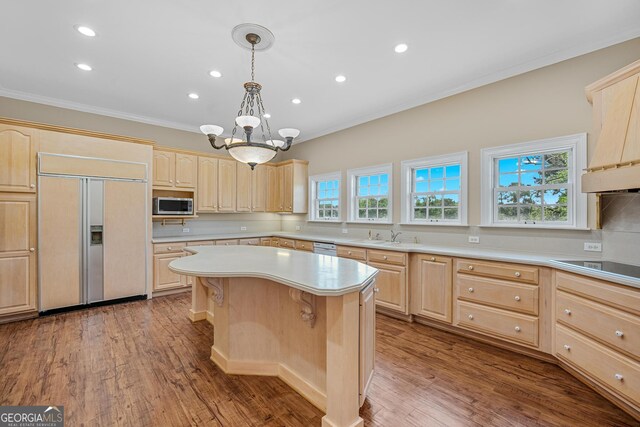 kitchen with light brown cabinetry, a center island, black electric stovetop, crown molding, and paneled refrigerator