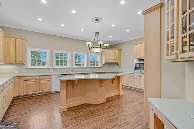 kitchen featuring a center island, white dishwasher, ornamental molding, stainless steel oven, and light brown cabinets