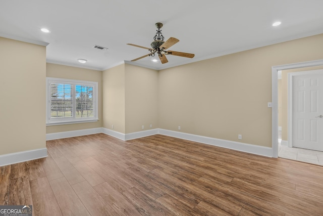 empty room with hardwood / wood-style floors, crown molding, and ceiling fan