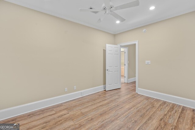 spare room featuring ceiling fan, ornamental molding, and light wood-type flooring