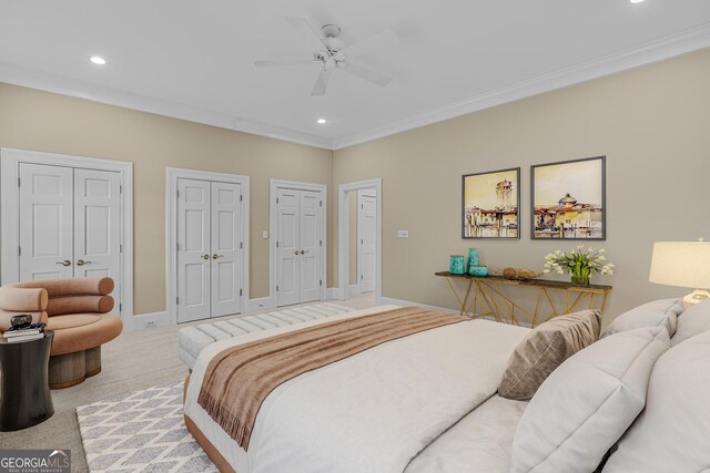 bedroom with multiple closets, crown molding, light carpet, and ceiling fan