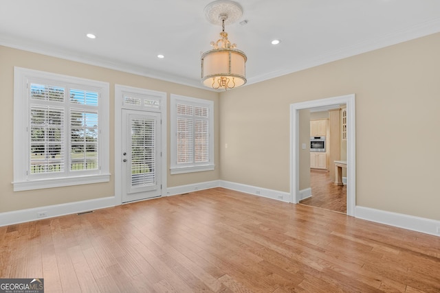 empty room with crown molding and hardwood / wood-style floors