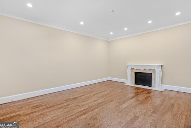 unfurnished living room with crown molding and light wood-type flooring