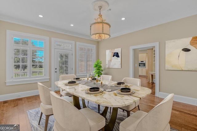 dining room featuring hardwood / wood-style floors and crown molding