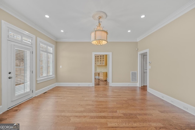 unfurnished dining area featuring crown molding and light hardwood / wood-style flooring