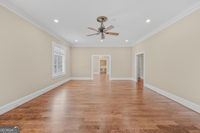 empty room with ceiling fan, ornamental molding, and light hardwood / wood-style floors