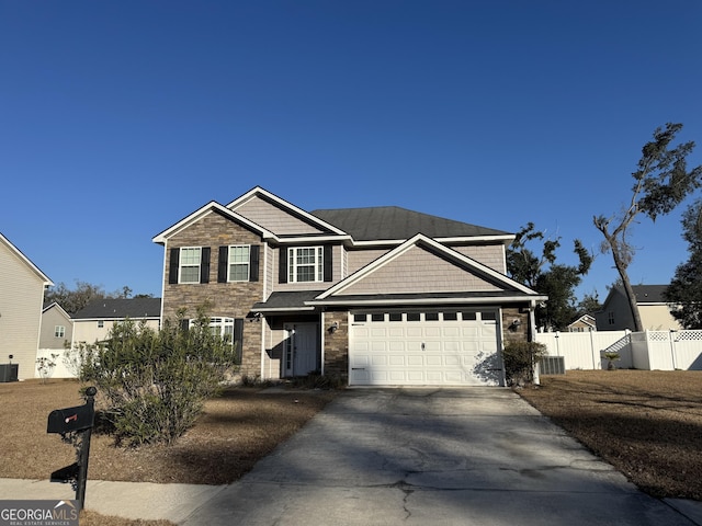 view of front of home featuring fence, a garage, cooling unit, stone siding, and driveway