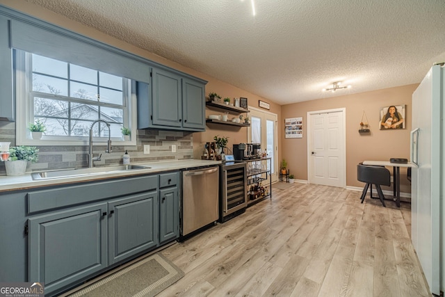 kitchen featuring sink, dishwasher, white refrigerator, light hardwood / wood-style floors, and beverage cooler