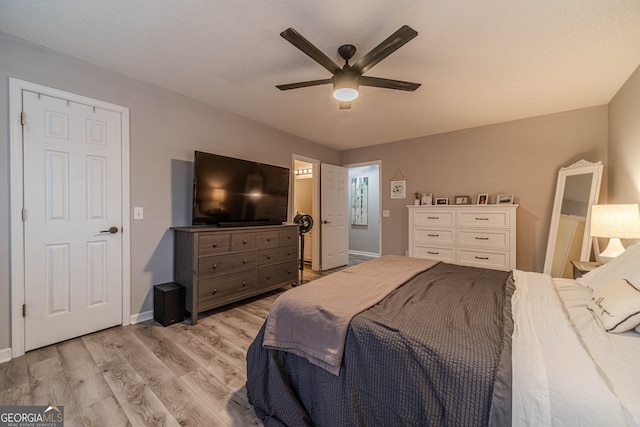 bedroom featuring ceiling fan, a textured ceiling, and light wood-type flooring