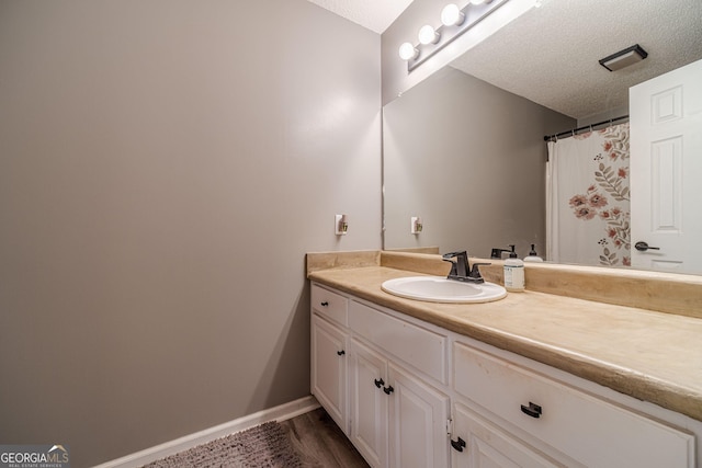 bathroom with vanity, wood-type flooring, and a textured ceiling