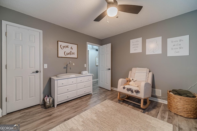 sitting room featuring sink, a textured ceiling, light hardwood / wood-style flooring, and ceiling fan