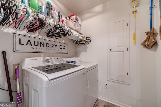 clothes washing area with hardwood / wood-style floors and independent washer and dryer