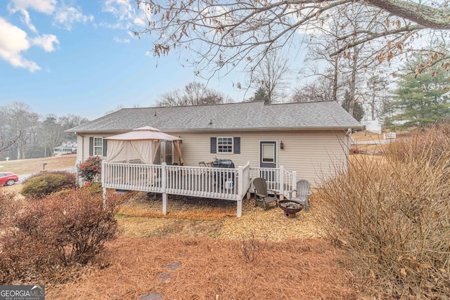 rear view of house with a gazebo and a wooden deck