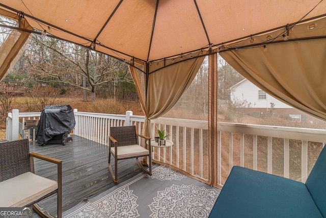 wooden deck featuring a gazebo and area for grilling