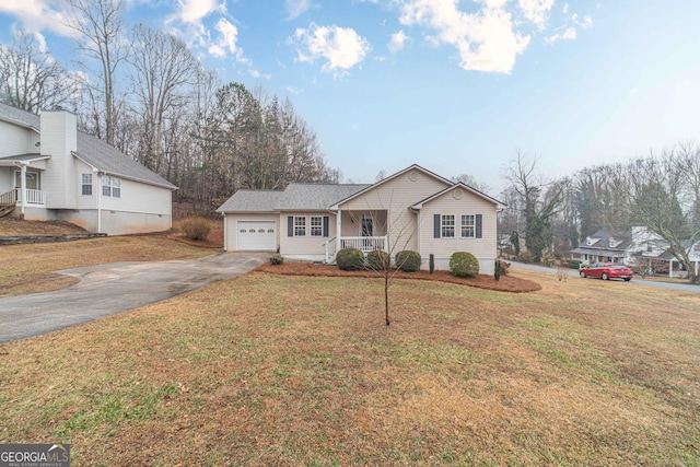 view of front of property with a garage, a front yard, and covered porch