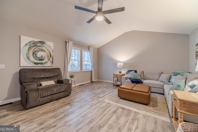 living room featuring vaulted ceiling, ceiling fan, and light wood-type flooring