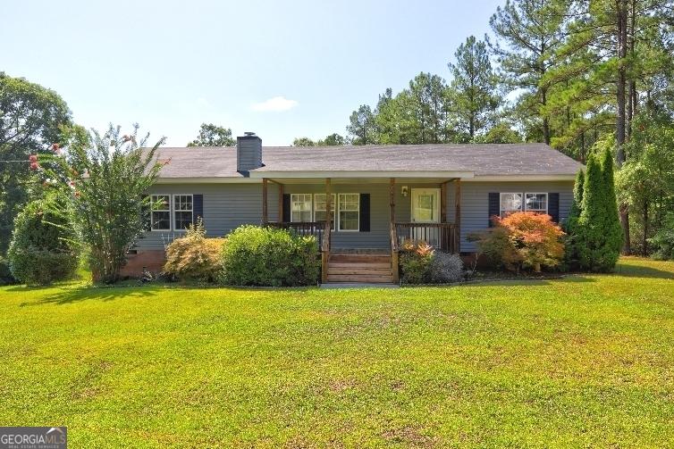 ranch-style house with covered porch and a front yard