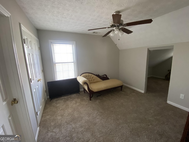 unfurnished room featuring vaulted ceiling, ceiling fan, carpet floors, and a textured ceiling