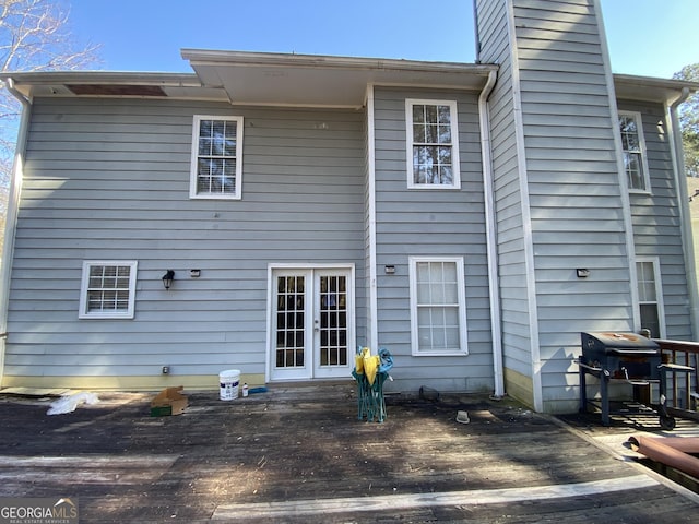 rear view of house with a wooden deck and french doors