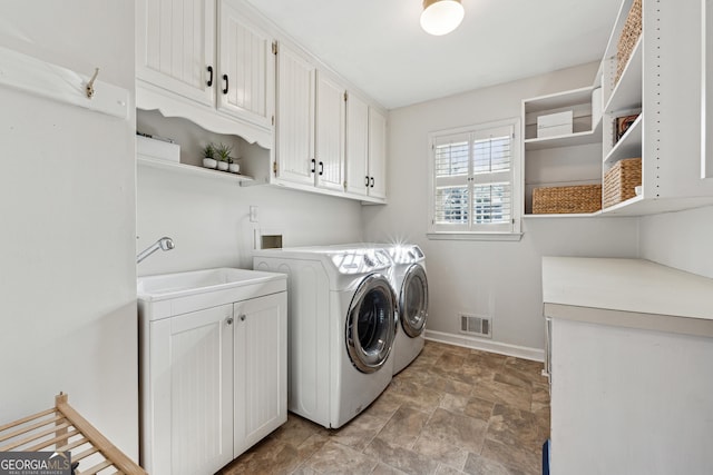 clothes washing area featuring cabinets, separate washer and dryer, and sink