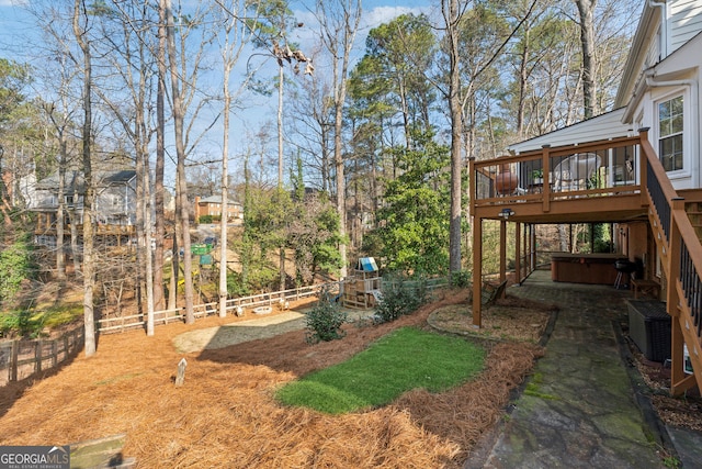 view of yard with a deck, central air condition unit, and a jacuzzi