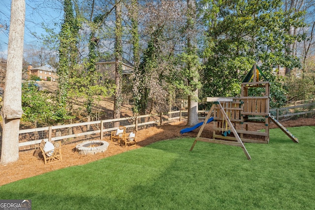 view of jungle gym with a yard and a fire pit