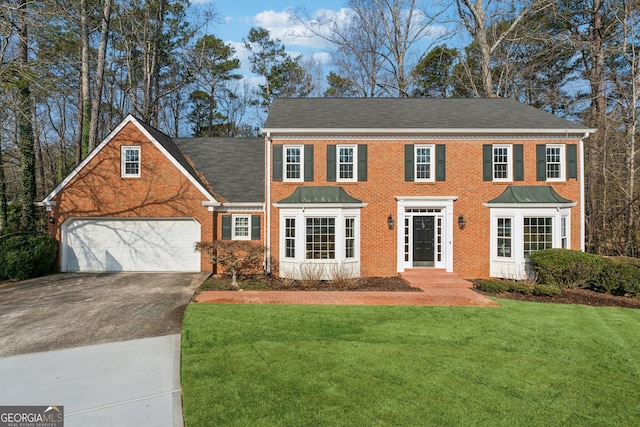 colonial inspired home with a garage and a front lawn