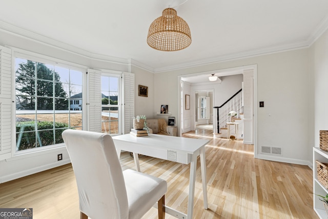 dining area featuring wood-type flooring and ornamental molding