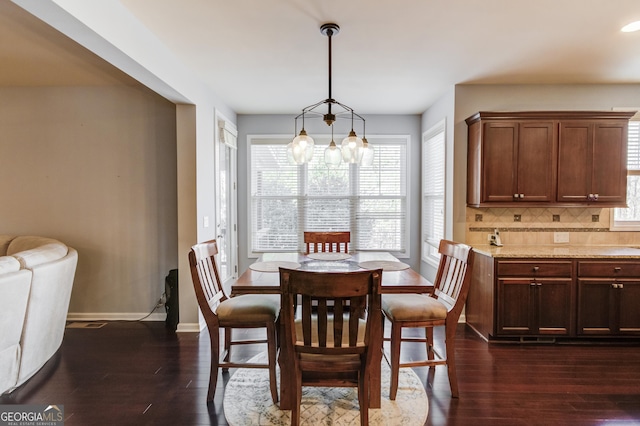 dining room with a notable chandelier and dark hardwood / wood-style floors