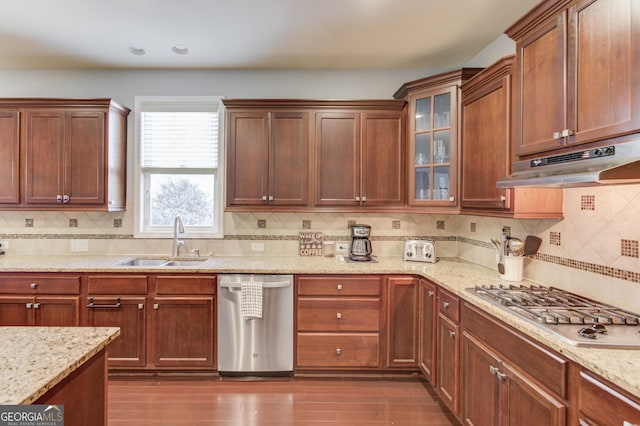 kitchen with dark wood-type flooring, stainless steel appliances, sink, and light stone counters