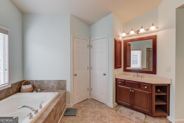 bathroom featuring vanity and tiled tub