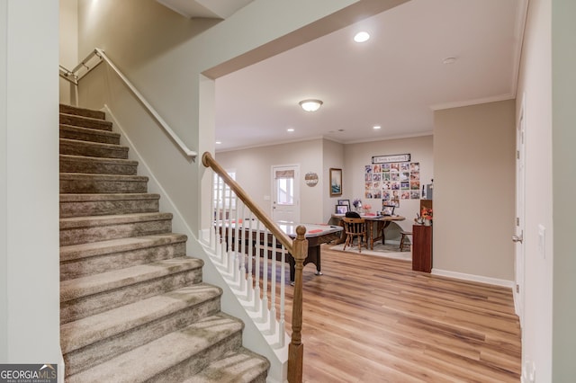 staircase featuring hardwood / wood-style flooring and crown molding