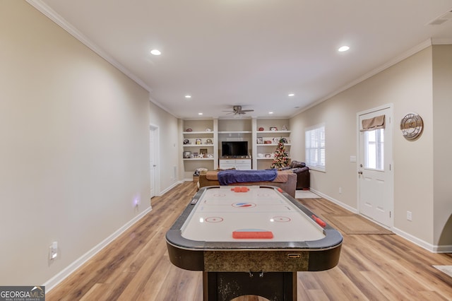 game room with ceiling fan, ornamental molding, light hardwood / wood-style flooring, and built in features