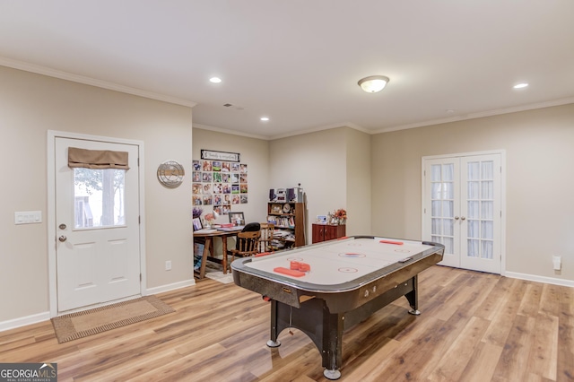 rec room with ornamental molding, light hardwood / wood-style floors, and french doors