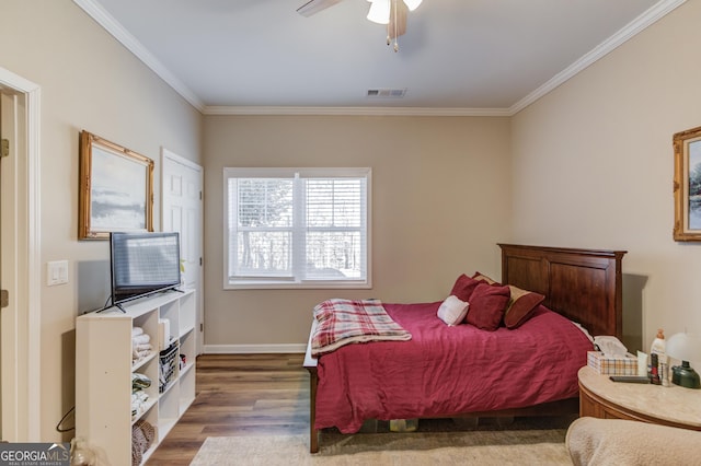 bedroom with crown molding, hardwood / wood-style floors, and ceiling fan