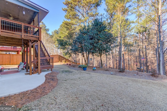 view of yard featuring ceiling fan, a deck, and a patio