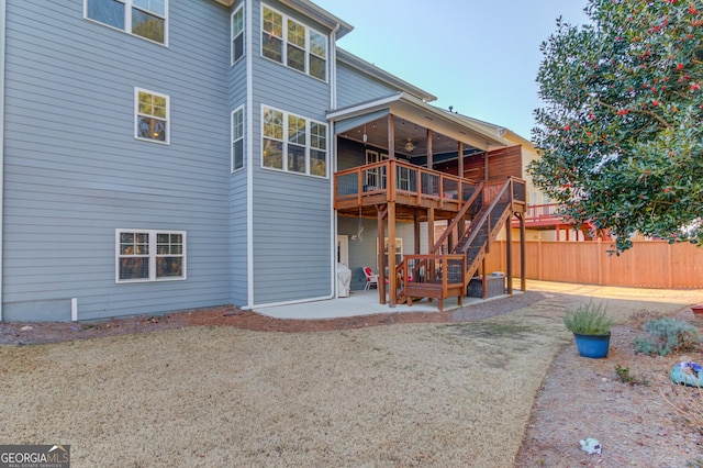 back of property with a wooden deck, a patio area, and ceiling fan