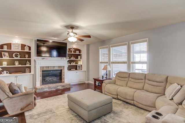 living room featuring ceiling fan, hardwood / wood-style floors, a fireplace, and built in shelves