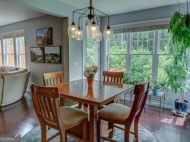 dining space with dark hardwood / wood-style floors and a chandelier