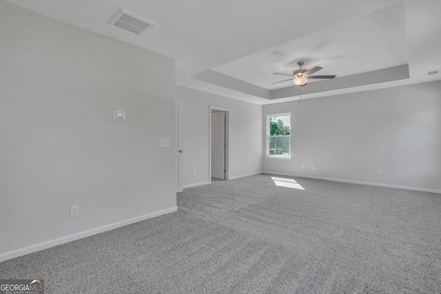 unfurnished room featuring carpet floors, ceiling fan, and a tray ceiling